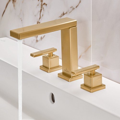 Ein Waschbecken mit goldenen Armaturen